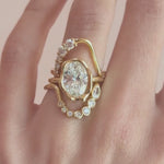 Video of The Abstract Bezel Oval Engagement Ring framed by two White Diamond Lucy Wave Bands on hand