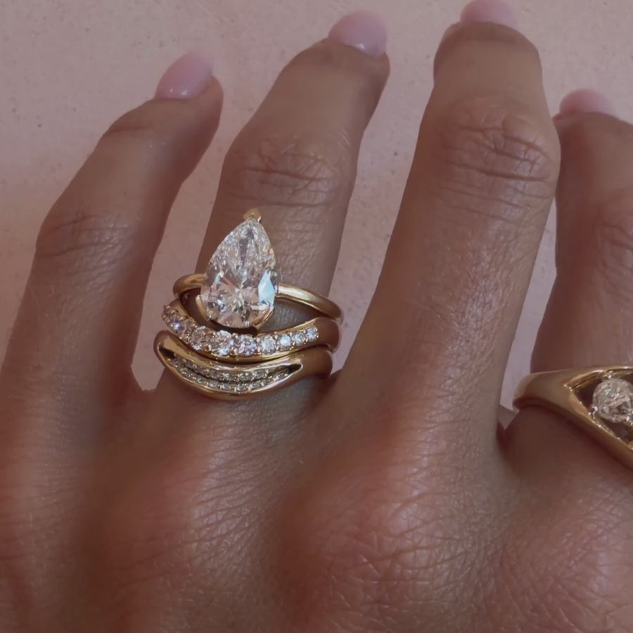 Video of the White Diamond Estelle Wave Band and White Diamond Rima Band stacked with a pear diamond engagement ring on hand