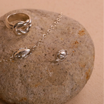 Silver ring and bracelet on a stone surface
