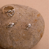 Silver ring and bracelet on a stone surface