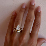 The Sloane Pear Solitaire Engagement Ring stacked with the White Diamond Bombé Band on hand