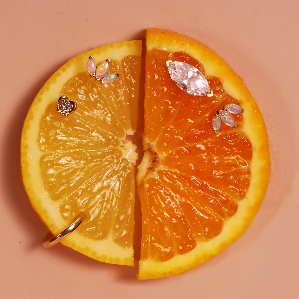 Sliced orange with earrings on a beige background