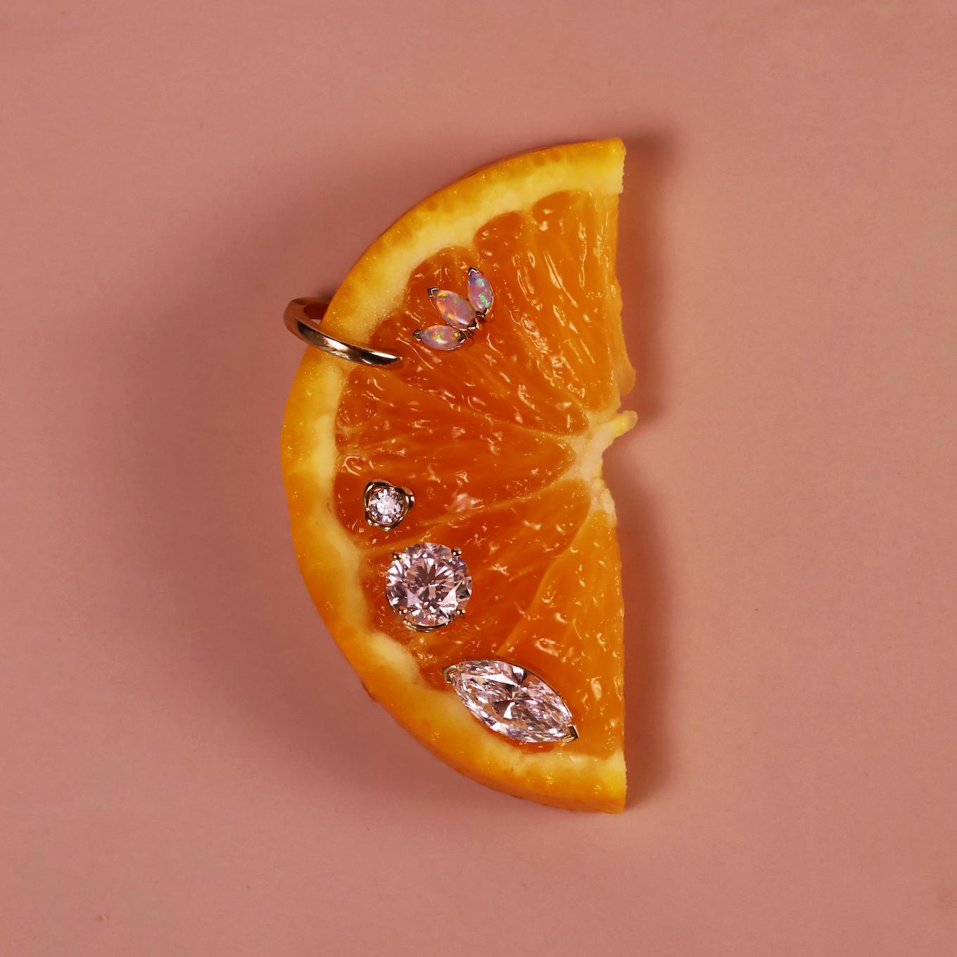 Orange wedge with diamond-shaped earrings on a beige background