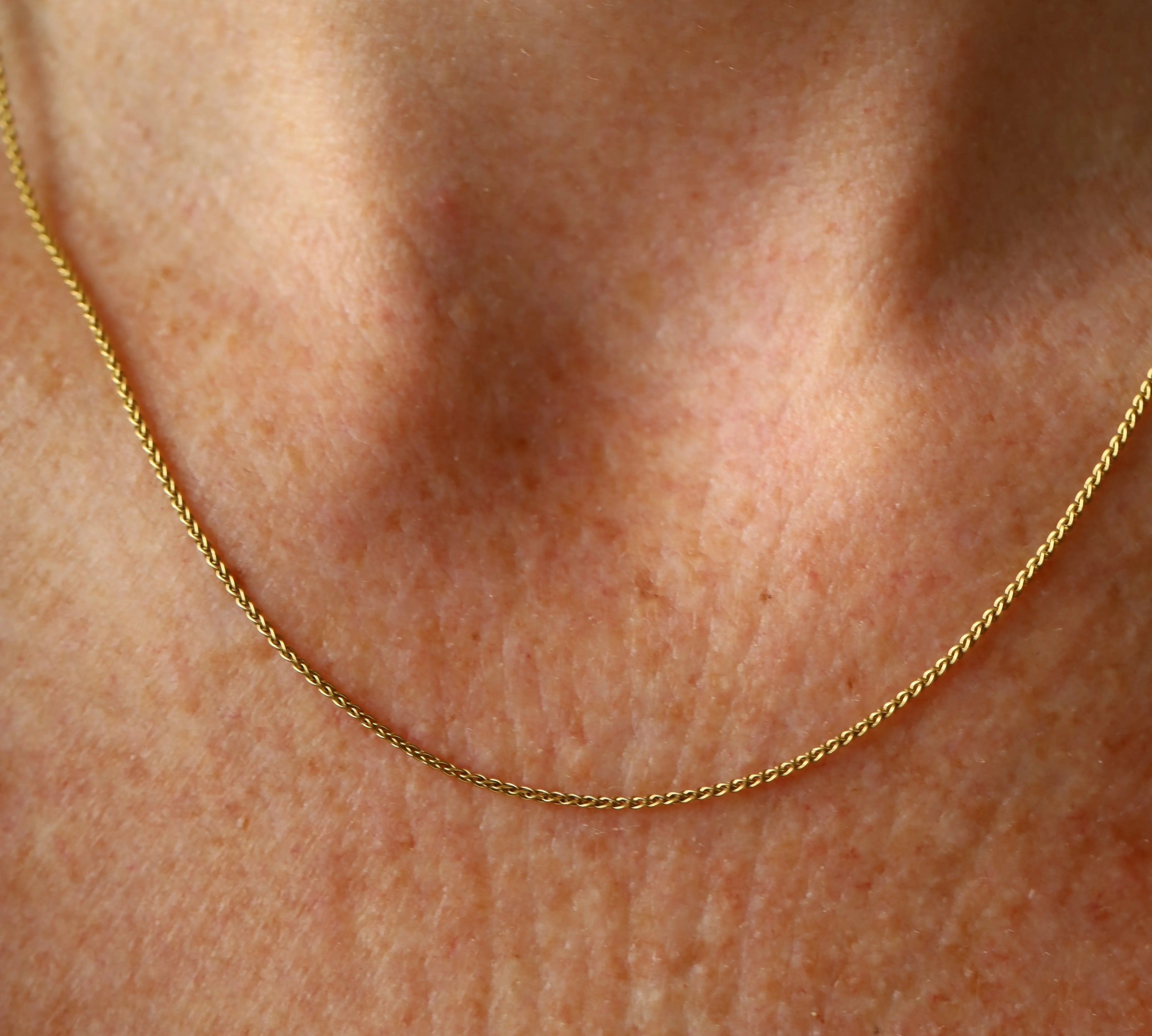Gold chain necklace on a person's neck